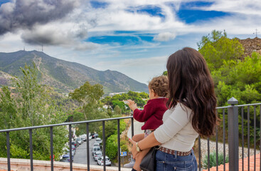 Fototapeta na wymiar mother and son looking at the horizon with mountains and clouds in the distance