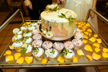 White wedding cake decorated by flowers fruits