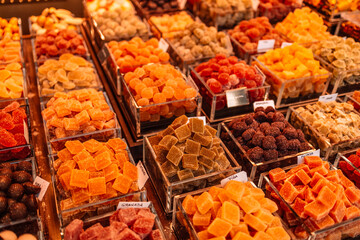 Market stall full of color fruit candy in La Boqueria Market. Barcelona. Catalonia. Market street shops