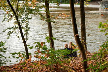 Couple sitting by river Isar in Munich