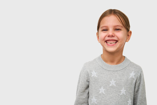 Cute little girl laughing on white background with copy space