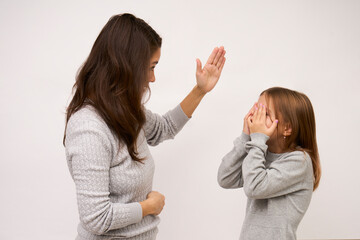 Angry mother beat up sad daughter on white background