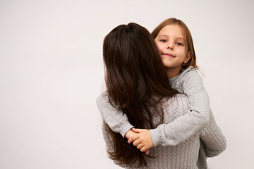Young mother hugging her little daughter