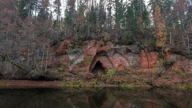Angels Cave, a Red Sandstone Cliff  in a Shape of Angel Wings, at the River Salaca in Skanaiskalns Nature Park in Mazsalaca, Latvia, Autumn Time. Sandstone Geological Formation