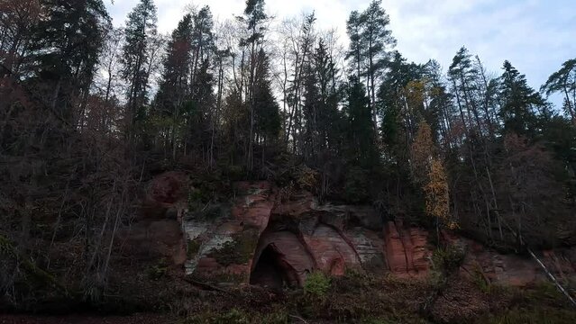 Angels Cave, a Red Sandstone Cliff  in a Shape of Angel Wings, at the River Salaca in Skanaiskalns Nature Park in Mazsalaca, Latvia, Autumn Time. Sandstone Geological Formation