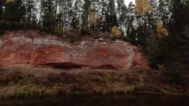 The Echo Cliff, Red Sandstone  Skanaiskalns Cliffs at the River Salaca in Skanaiskalns Nature Park  Mazsalaca, Latvia, Autumn Time. Sandstone Geological Formation