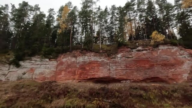 The Echo Cliff, Red Sandstone  Skanaiskalns Cliffs at the River Salaca in Skanaiskalns Nature Park  Mazsalaca, Latvia, Autumn Time. Sandstone Geological Formation