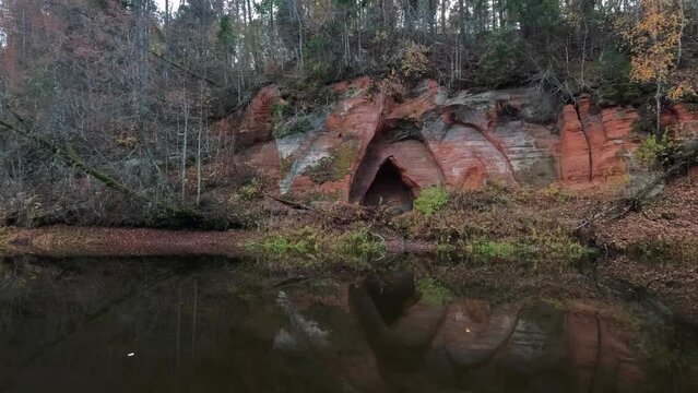 Angels Cave, a Red Sandstone Cliff  in a Shape of Angel Wings, at the River Salaca in Skanaiskalns Nature Park in Mazsalaca, Latvia, Autumn Time. Sandstone Geological Formation
