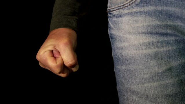 An Angry Man Clenching the Fist on black background. One Person Getting Mad and Clench the Hand Fingers in a Fist. Close up