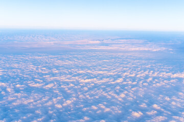 Background of a pink heavenly sky with fluffy dense clouds, top view from an airplane. Can be used as advertising background, overlay. Travel concept.