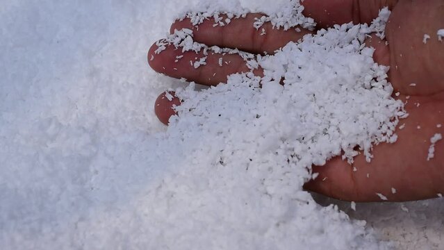 Human hand with white polystyrene beads, recycled plastic concept.