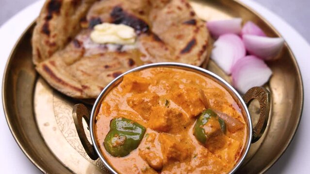 Kadai Paneer is a spicy, flavourful and delicious gravy dish made with  paneer, bell pepper, and onion in a freshly ground spice and served with  lachcha parantha and onion 