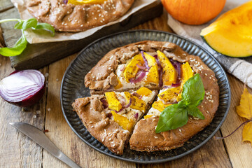 Homemade galette pie or crostata with pumpkin and ricotta cheese on rustic  background. Thanksgiving day food.