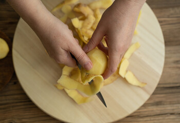Peeling and Slicing Potatoes on Wooden Cutting Board