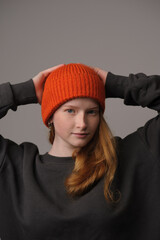 young girl model in orange cap isolated on gray background. Product photo mockup for fashion brands and marketplaces.