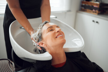 Hair, smile and wash, woman in salon relax with head back and hairdresser cleaning with shampoo and...