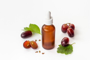 Bottle of grape seed essential oil with grapes. Eco cosmetic product