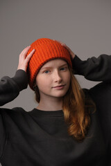 young girl model in orange cap isolated on gray background. Product photo mockup for fashion brands and marketplaces.