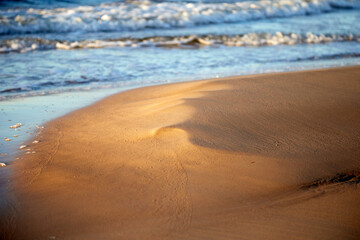 Fototapeta na wymiar Beach sand surrounded of sea waves, selective focus