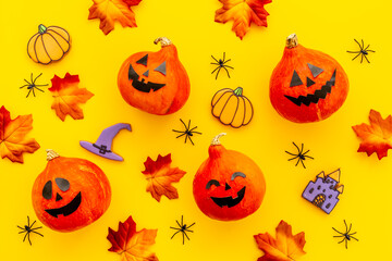 Flat lay of orange Halloween pumpkins and dry leaves, top view