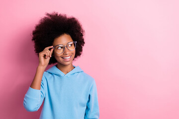 Photo portrait of adorable pupil girl look empty space touch eyewear smart wear trendy blue garment isolated on pink color background