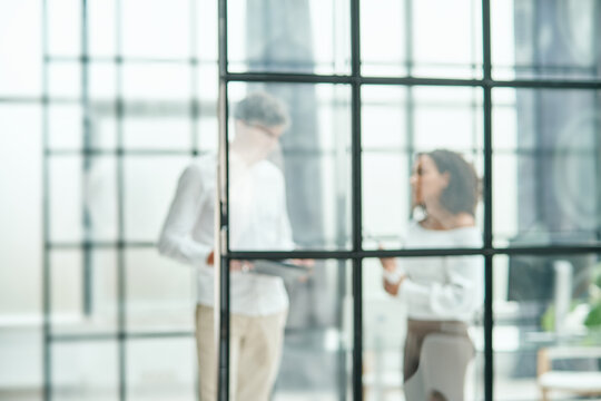 blurry image, business background. business colleagues behind a glass office wall.