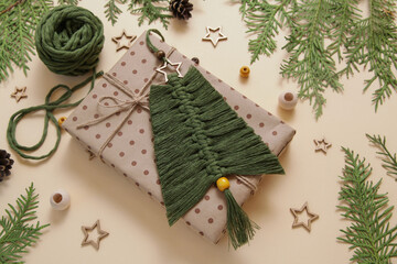 Green Macrame christmas tree in natural color and wooden beards, wooden stars on a wooden table. Cotton rope decor macrame. Woman hobby. Present Christmas, Winter and New Year concept