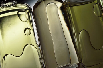 transparent jars with perfume lie on a light background. Close-up