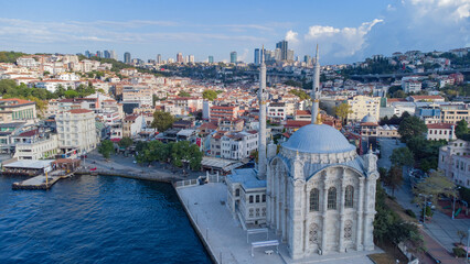 Obraz premium Skyscrapers of istanbul behind Ortaköy Camii mosque and city behind, aerial view of the Bosporous in Istanbul