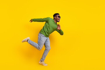 Fototapeta na wymiar Full length body size view of attractive cheerful guy running fooling having fun isolated on bright yellow color background