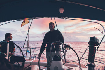 Man sailing on sunset sea - obrazy, fototapety, plakaty