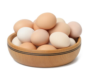 Raw brown and white chicken eggs in a wooden plate