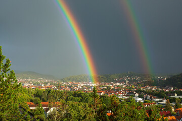 after an autumn thunderstorm, a double rainbow over the city