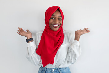 Who cares. Carefree african american muslim woman in hijab spreading hands and shrugging shoulders, white wall