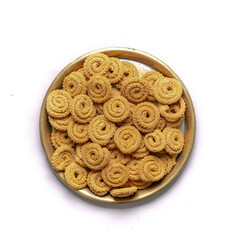 Crunchy fried homemade Chakli,chakkuli, murukku in a wooden traditional plate on white background top view