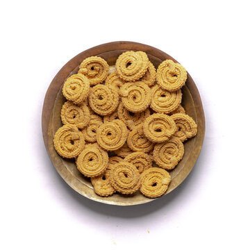 Crunchy fried homemade Chakli,chakkuli, murukku in a wooden traditional plate on white background top view