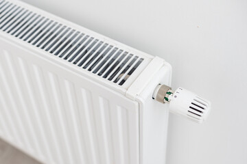 White radiator with temperature control valve. Central heating battery