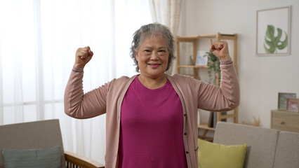 front portrait of a strong healthy asian senior old female looking at the camera with a  smile...