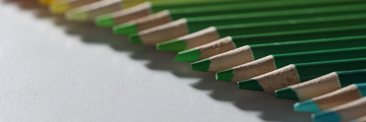 Colored pencils lie in a row on the table, blurry