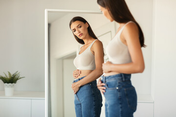 Unhappy Lady Touching Flat Belly Having Stomachache Standing At Home