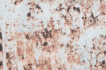 Rusty sheet of metal with peeling faded paint, covered with dust and dirt, grungy texture surface, close-up vintage background.