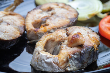 Acorn slices in a black plate ; Bonito fish grill