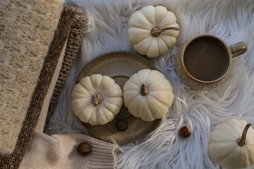 Autumn cozy composition. Autumn flat lay with a cup of coffee and white pumpkins on a white background. Flat lay, top view.