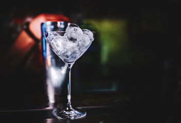 Ice cube in an empty glass on a bar counter in bar or pub