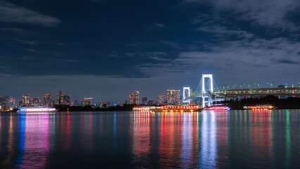 Fototapeta na wymiar 東京都 お台場海浜公園から見えるレインボーブリッジと屋形船の浮かぶ東京湾の夜景