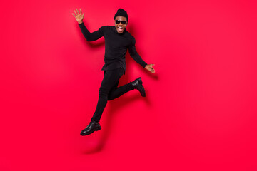 Fototapeta na wymiar Full length body size view of attractive trendy cheerful guy jumping dancing rest isolated over bright red color background