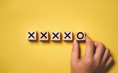 Hand arrange circle sign from cross sign on wooden block cube for fail to success  and effort...