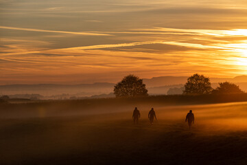 colorful sunrise with people in the mist
