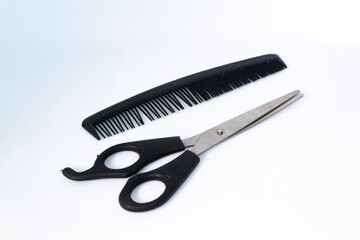 One black comb and scissors. Isolated on white background.