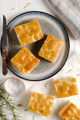 Italian focaccia on white wooden table.